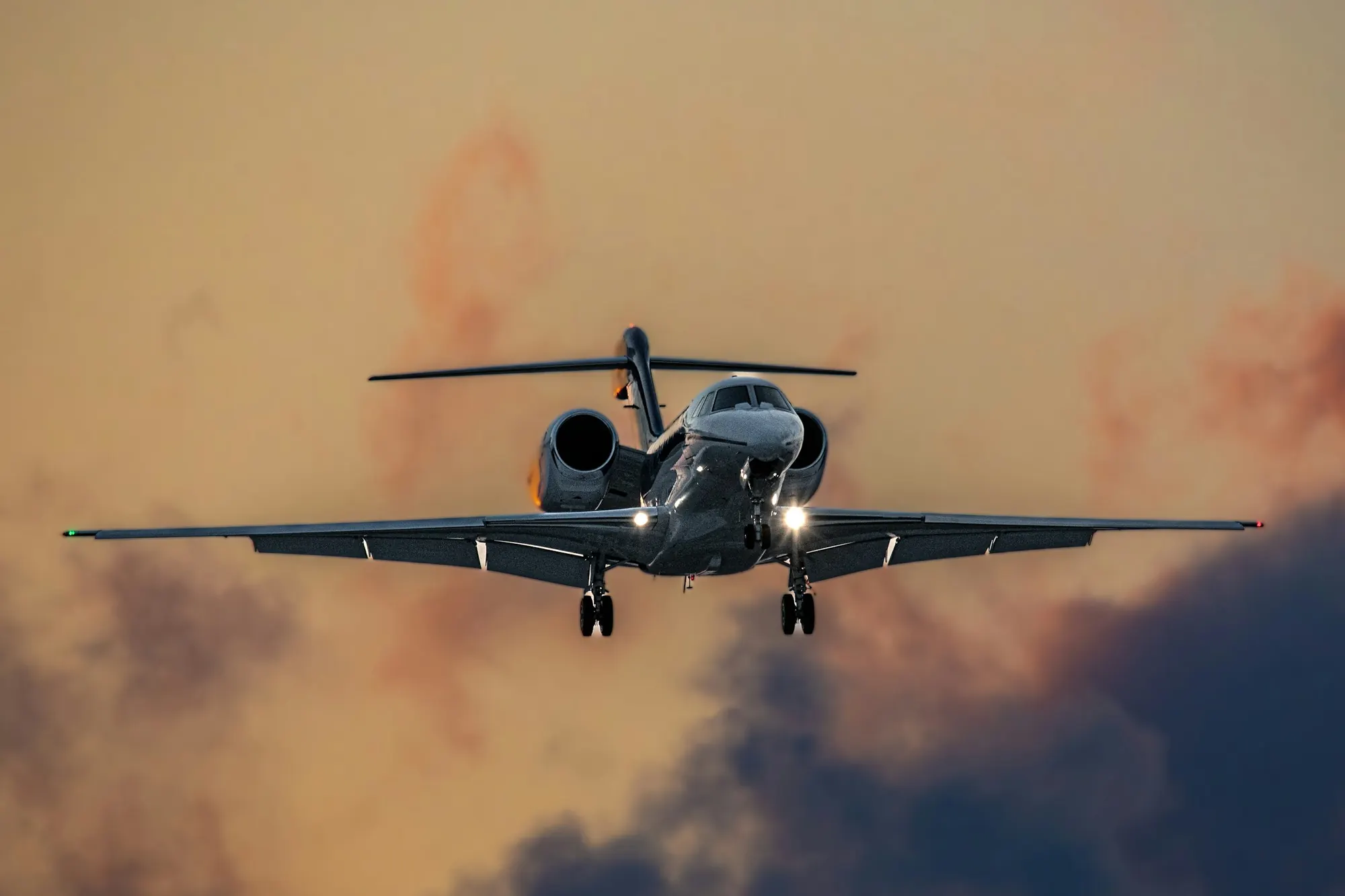 Business jet on approach, wheels down, under a grey sky