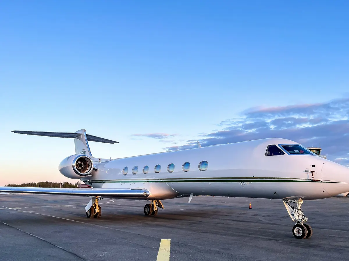 Large-cabin jet parked on the ramp under a blue sky