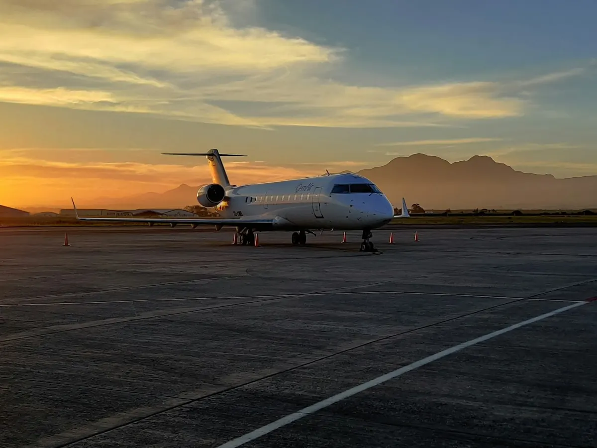 Business jet parked on a wide ramp at sunset